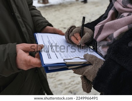 Activist collecting signatures for a petition Royalty-Free Stock Photo #2249966491