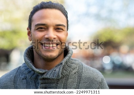 Close up portrait of good looking young multi race guy in sweater outside in the city on a winter day