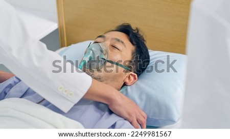 A middle-aged male patient in a coma in a hospital bed. Royalty-Free Stock Photo #2249981567