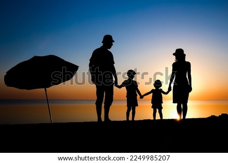 Happy family by the sea at sunset in travel silhouette in nature