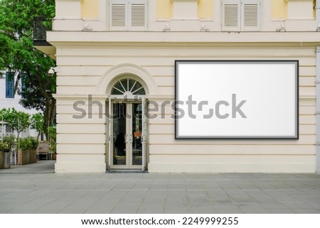 Large horizontal blank advertising poster billboard banner mockup on wall of building in urban city; digital light box display screen for OOH media. 12 sheet out-of-home
