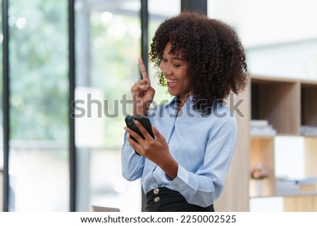  black woman having phone conversation with client in office. African american young woman using smart phone