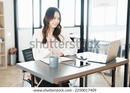 Portrait of a beautiful Asian teenage girl using computer for video conferencing at office.