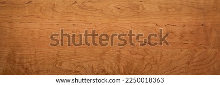 Wooden board desktop. Cherry wood wood board long desktop background. Wide solid wood desktop. The natural texture of the wooden board.