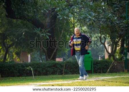 Indian old man running or jogging at park Royalty-Free Stock Photo #2250020295