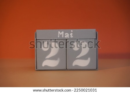 22 Mai on wooden grey cubes. Calendar cube date 22 May. Concept of date. Copy space for text or event. Educational cubes. Wood blocks in box with german date, day and month. Selective focus