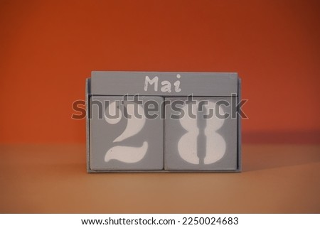 28 Mai on wooden grey cubes. Calendar cube date 28 May. Concept of date. Copy space for text or event. Educational cubes. Wood blocks in box with german date, day and month. Selective focus