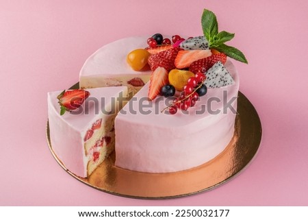 Pink cream cheese cake with strawberry decorated berry and mint
Beautiful delicious birthday cake with layers on the pink background, one  slice removed. Royalty-Free Stock Photo #2250032177