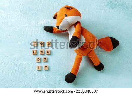 You can do it, motivational banner with a toy fox on a blue background, inspirational saying, a flat lay