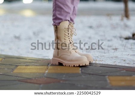 Woman winter boots on snow close-up photo of winter shoes. Blurred background. Selective focus