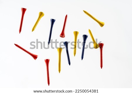 color wooden bamboo golf tees fallnig through the air isolated on a wooden background