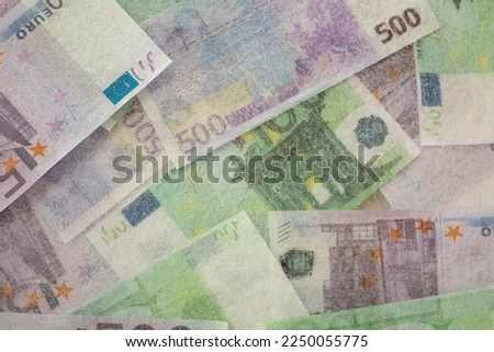 Blurred and defocused photo of one hundred and five hundred euros are defrosted in ice. The European cash currency is frozen. 