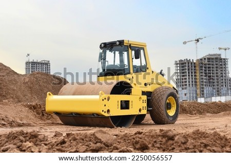 Soil Compactor for leveling ground for foundation and on road construction. Road compaction equipment at construction site. Vibration single-cylinder road roller on sunset. Building construction. Royalty-Free Stock Photo #2250056557