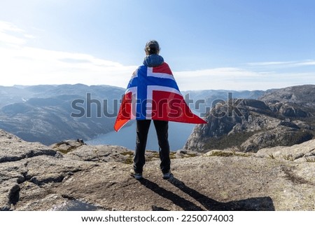 Woman with a waving flag of Norway on the background of nature Royalty-Free Stock Photo #2250074003