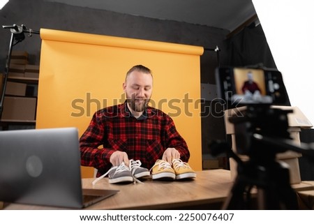 Young man blogger or vlogger looking at camera working reviewing product for internet store. Business online influencer on social media concept.
