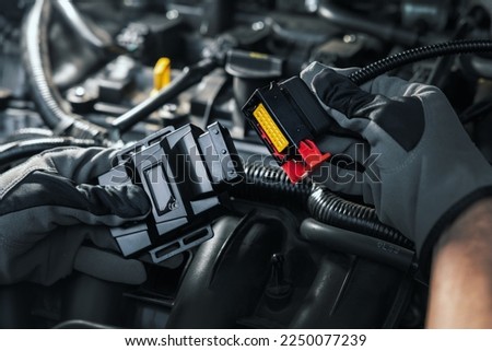 mechanic installing chip tuning box on car engine Royalty-Free Stock Photo #2250077239