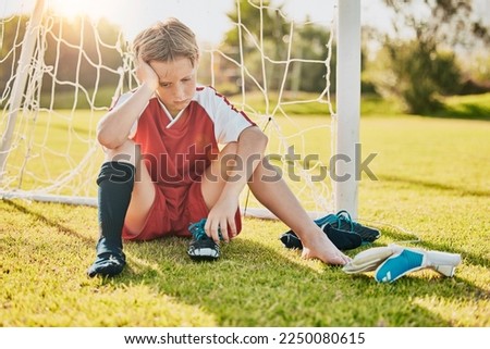 Sports, football loss and child sad over fitness game defeat, training competition fail or athlete contest. Kid depression, mental health problem and youth player depressed from soccer field bullying Royalty-Free Stock Photo #2250080615