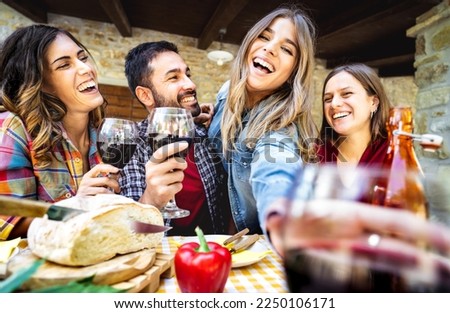 Young people having fun drinking wine out side at farm house bar patio - Happy friends enjoying harvest time together at countryside homestead - Youth life style concept on wide angle point of view