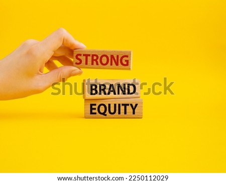 Strong Brand Equity symbol. Concept words Strong Brand Equity on wooden blocks. Businessman hand. Beautiful yellow background. Business and Strong Brand Equity concept. Copy space