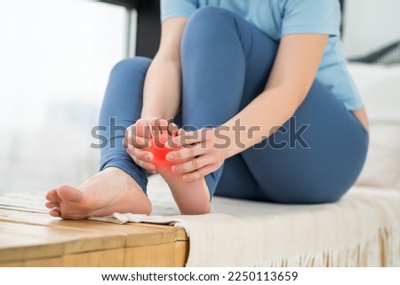 Joint diseases, hallux valgus, plantar fasciitis, heel spur, woman's leg hurts, pain in the foot, massage of female feet at home, health problems concept Royalty-Free Stock Photo #2250113659