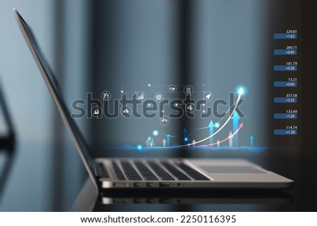 Computer laptop with graph chart on worktable.