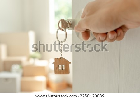 Moving house, relocation. Man open new room in new apartment, inside the room was a cardboard box containing personal belongings and furniture. move in the apartment or condominium Royalty-Free Stock Photo #2250120089