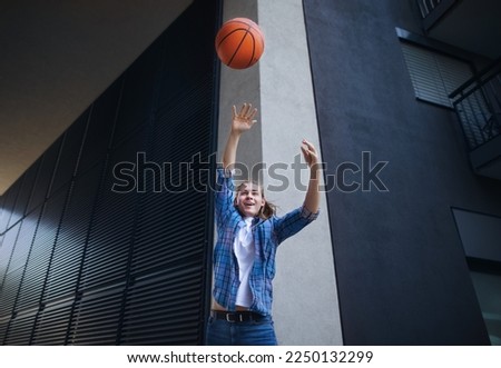 Young man throwing away basketball ball,outdoor in city. Youth culture.