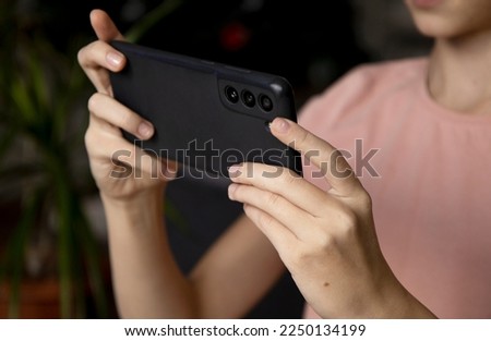Hands of a girl with a smartphone close-up. Take a selfie on your phone or shoot a video for social networks. Free time on the Internet, instant messengers, smartphone applications. Royalty-Free Stock Photo #2250134199