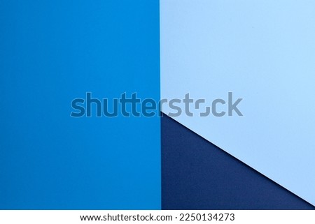 Multilayered colored paper background in blue tones. Abstract geometric flat composition. Empty space on multicolored cardboard. Diagonal, triangules and lines. Top view. Royalty-Free Stock Photo #2250134273