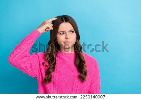 Photo of doubtful unsure lady wear pink sweater finger head looking empty space isolated blue color background