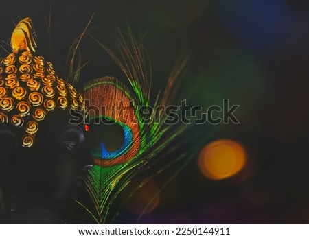 buddha background with soft focus.selective focus on buddha face.peaceful smiling buddha background with peacock feather over a black backdrop with bokeh lights.calm and meditative backgrounds.