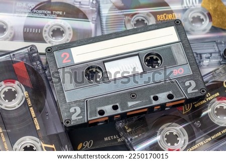 One audio cassette tape lying on a pile of audio cassettes lying on top of each other Royalty-Free Stock Photo #2250170015
