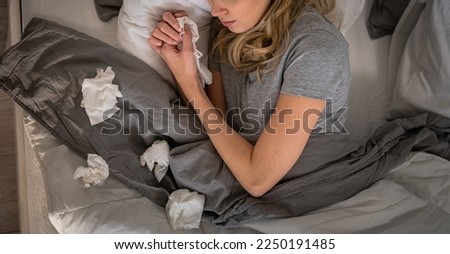 Sick day at home. Woman has runny and common cold. Cough. Closeup Of Beautiful Young Woman Caught Cold Or Flu Illness. Portrait Of Unhealthy Girl In Feeling Pain In Throat. Royalty-Free Stock Photo #2250191485