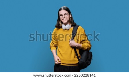 Portrait of university student guy on blue studio background