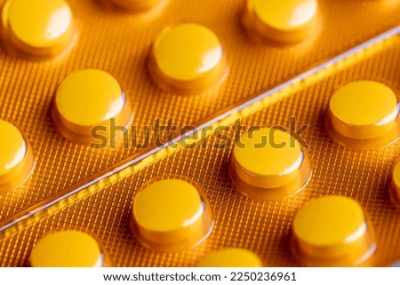 Tablets packed in a yellow blister, a package of tablets closed in a transparent package