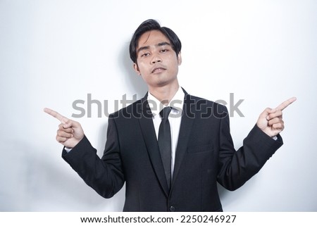 Handsome hispanic man wearing suit and tie smiling confident pointing with fingers to different directions. copy space for advertisement