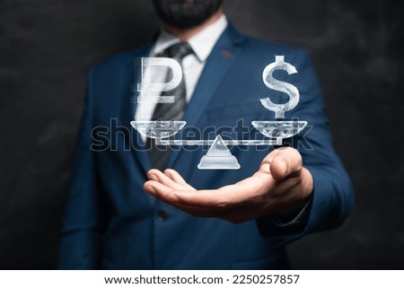 On the scales dollar and rubles from the network. Man holding in his hand