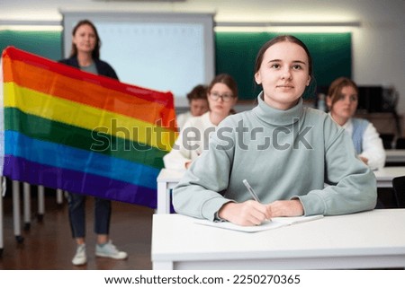 Teacher explaining meaning of LGBT flag to students in school