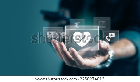 Businessman holding virtual medical health care icons in modern graphic interface. Health service innovation and Insurance Concept