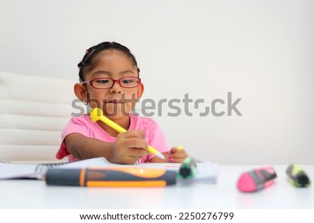 4-year-old brunette Latina girl with autism spectrum disorder ASD like Asperger, Rett and Heller draws at a desk, plays with colors alone antisocial Royalty-Free Stock Photo #2250276799