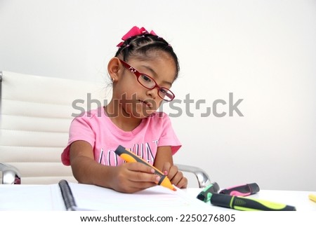 4-year-old brunette Latina girl with autism spectrum disorder ASD like Asperger, Rett and Heller draws at a desk, plays with colors alone antisocial Royalty-Free Stock Photo #2250276805