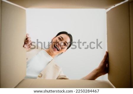 Surprised young asian woman unpacking. Opening carton box and looking inside. Packaging box, delivery service. Human emotions and facial expression Royalty-Free Stock Photo #2250284467