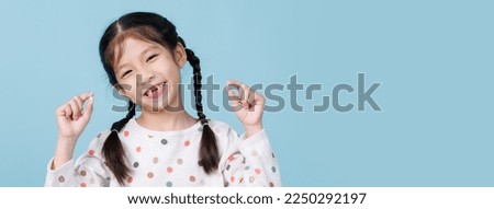 7 Years old child has loose tooth, Dentistry and Health care concept, Empty space isolated on blue background Royalty-Free Stock Photo #2250292197