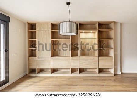 Beautiful custom made oak bookcase with display cabinet, drawers, drawers and shelves in an apartment with wooden flooring Royalty-Free Stock Photo #2250296281