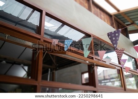 Festive colorful flags decorated on wooden architecture, stock photo