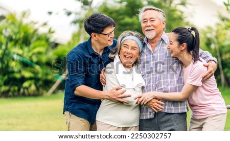 Portrait enjoy happy smiling love multi-generation asian big hug family.Senior mature father and elderly mother with young adult woman and son outdoor in park at home.insurance concept Royalty-Free Stock Photo #2250302757