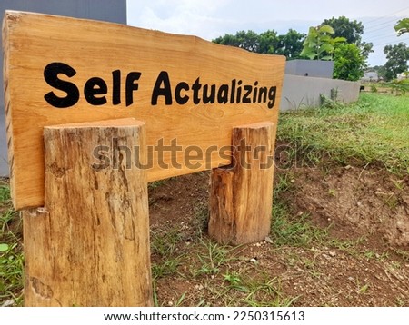 Brown wood inscribed with words for productivity and motivation about self-actualization and mindfulness Royalty-Free Stock Photo #2250315613