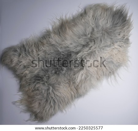 Gray sheep skin rug on white floor Royalty-Free Stock Photo #2250325577