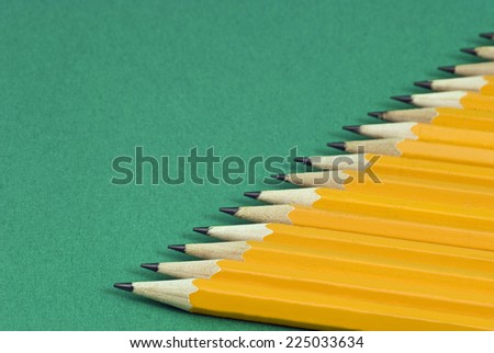 Horizontal Shot Of Row Of Pencils On Green Background/ Focus On Front