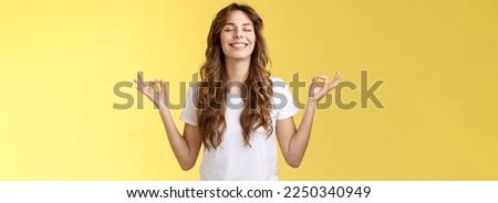 Patience, happiness, wellbeing. Cheerful relieved attractive peaceful relaxed young happy girl breathe inhale air smiling broadly close eyes lean sunlight meditating zen gesture hands sideways yoga. Royalty-Free Stock Photo #2250340949